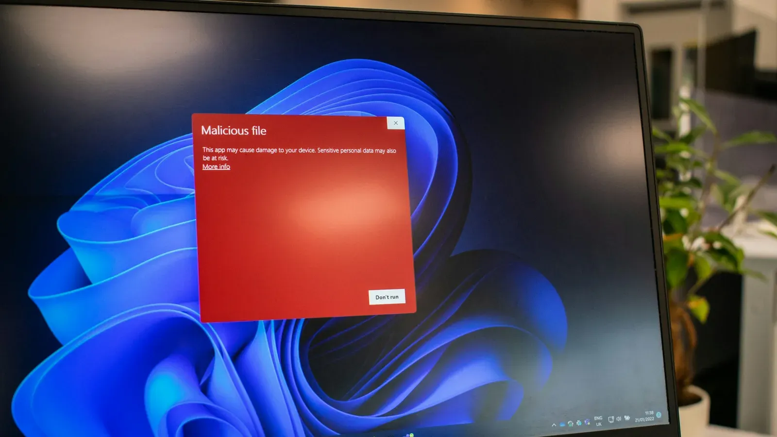 Laptop Dell cu ecranul colorat în roșu, pe un birou